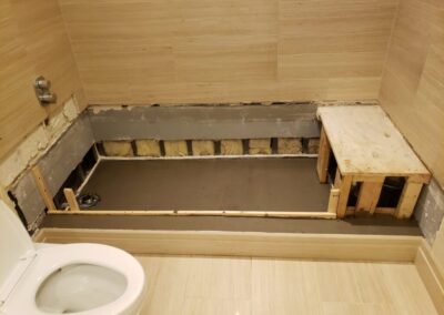 A white toilet sitting next to a wooden wall