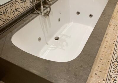 A bathtub in a bathroom with a mirror above it