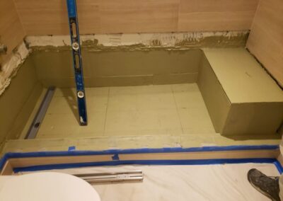 A bathroom that is being remodeled with a blue tape on the floor