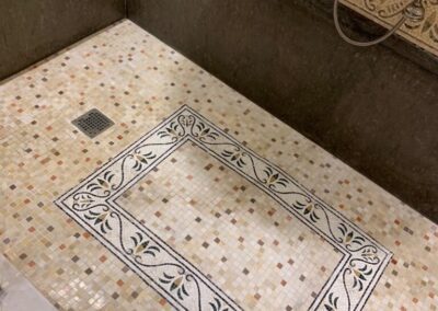 A bathroom with a tiled floor and a shower