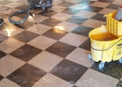 A couple of men are cleaning a checkered floor