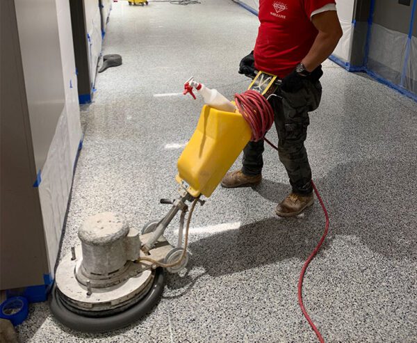 a man is carring maintenance on hose floor with cleaning machine